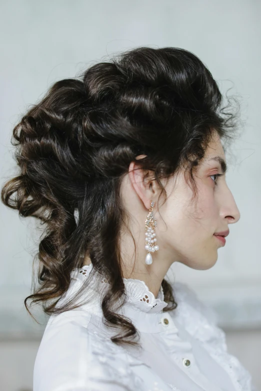 a woman with a long, hair up and a pearl earrings