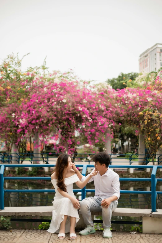 young couple sitting on bench in park and touching foreheads