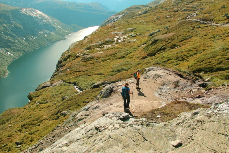 two people walking on the mountain side