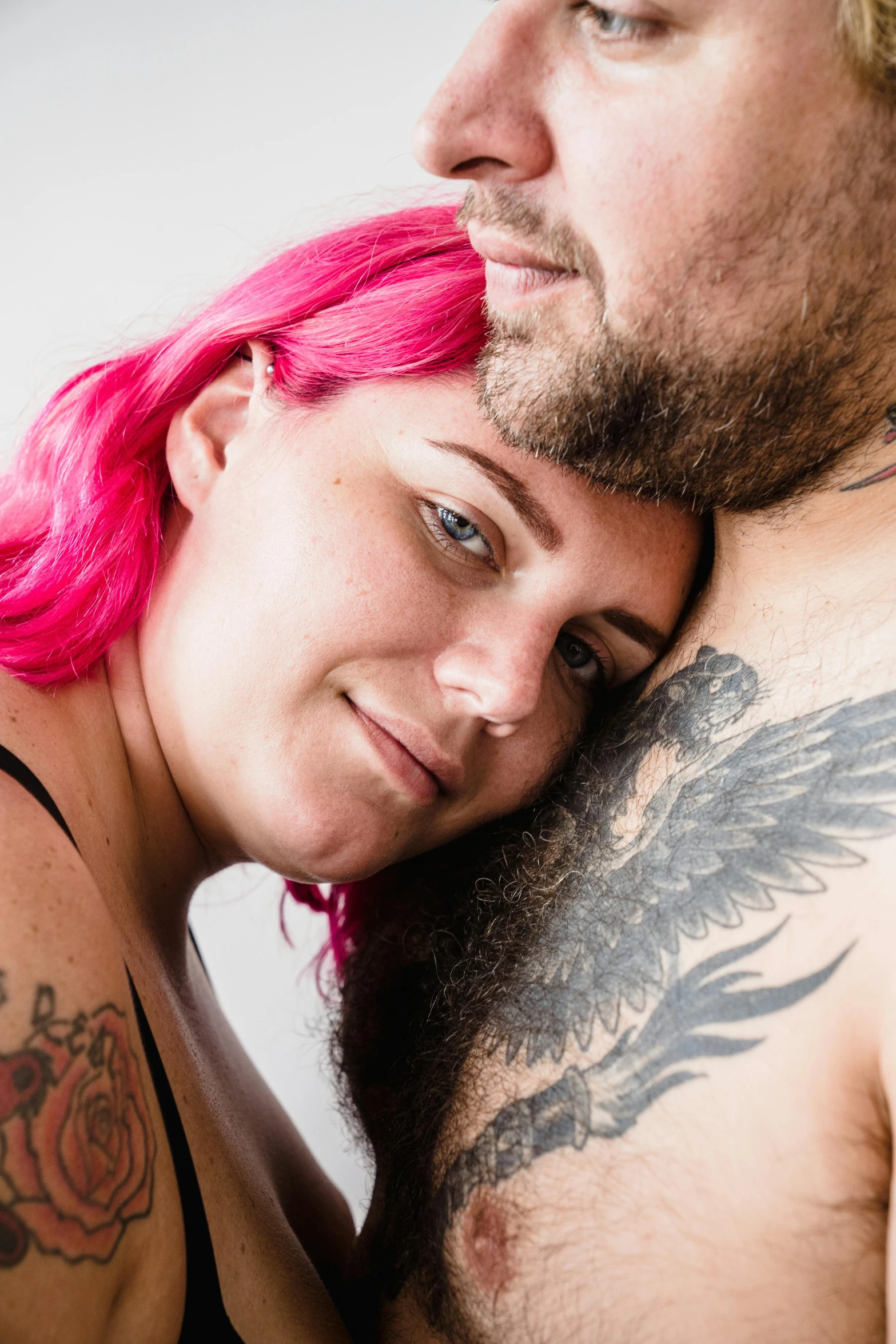 a man with a pink hair and his wife is posing for the camera