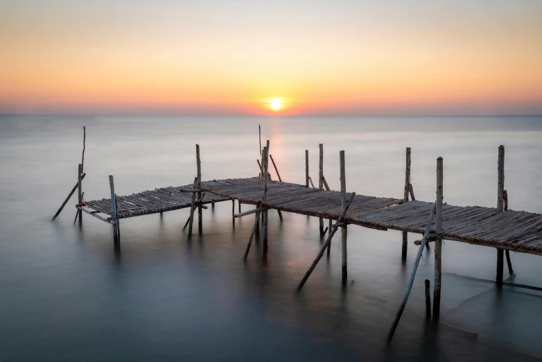 a pier in the ocean during sunset or sunset