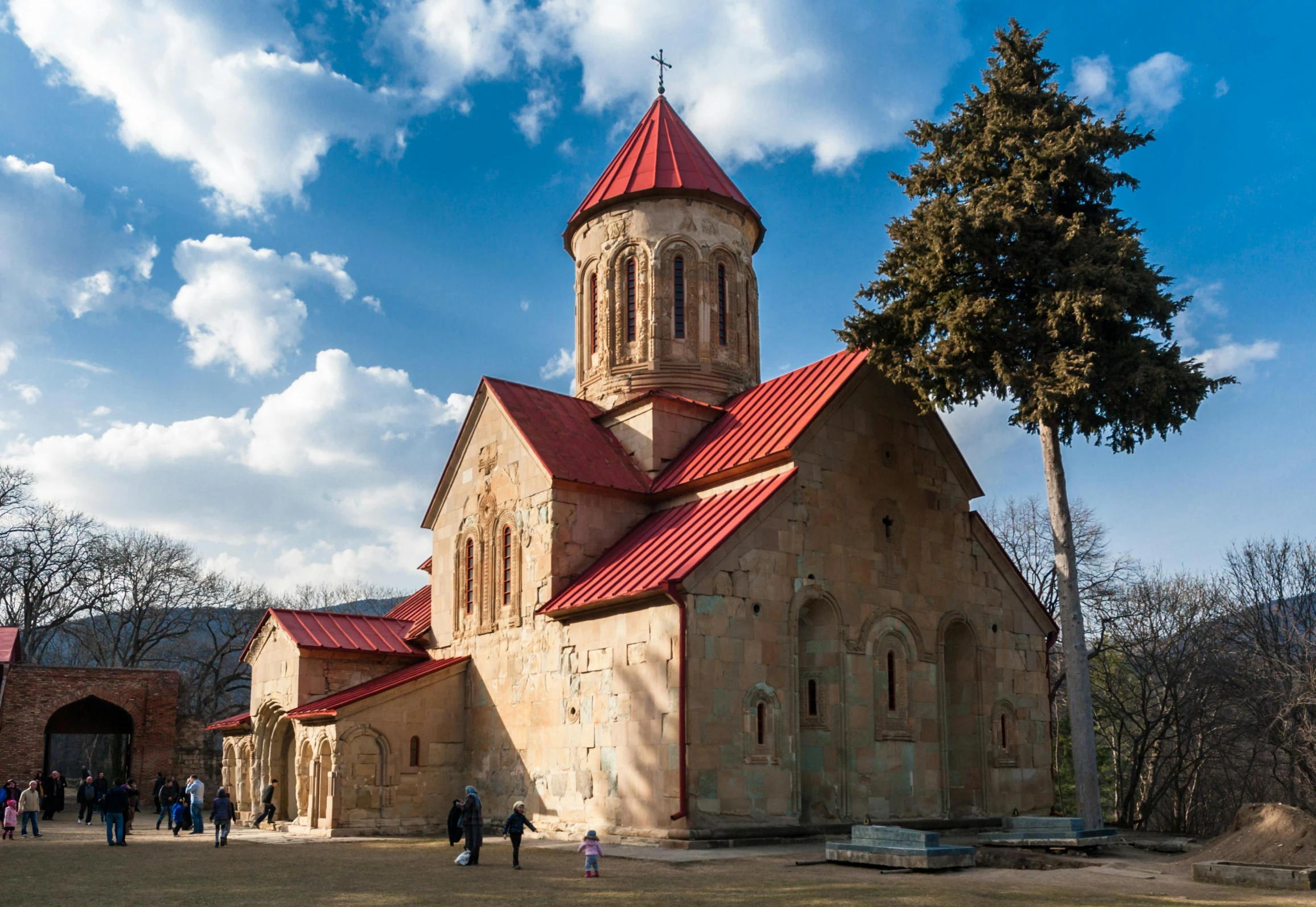 some people walking in front of an old church