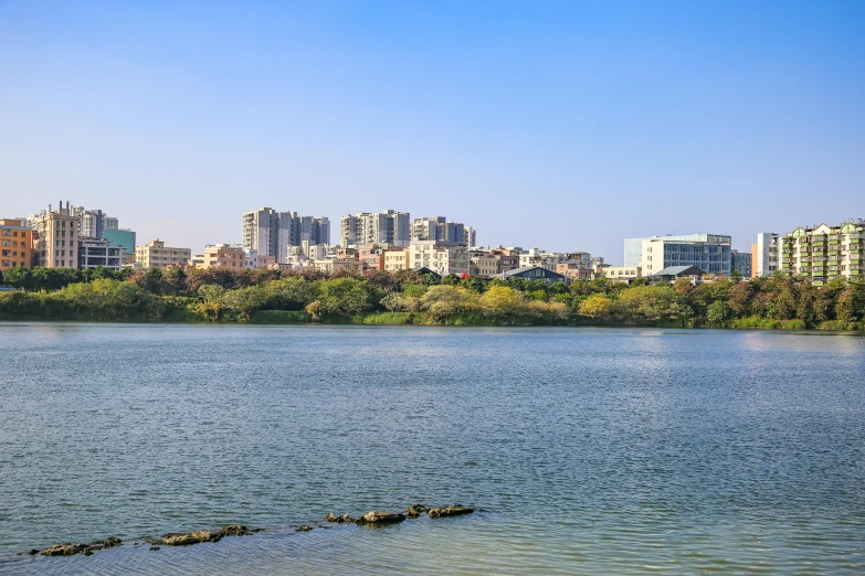 water with cityscape in the background, and a boat traveling along