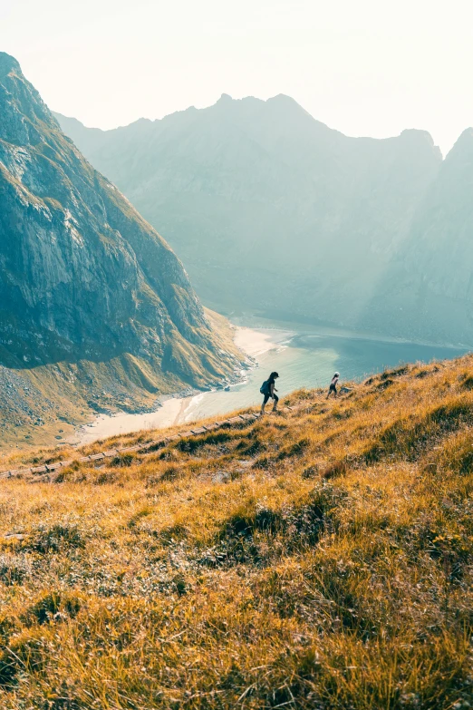 man riding horse uphill on hillside overlooking mountain pass