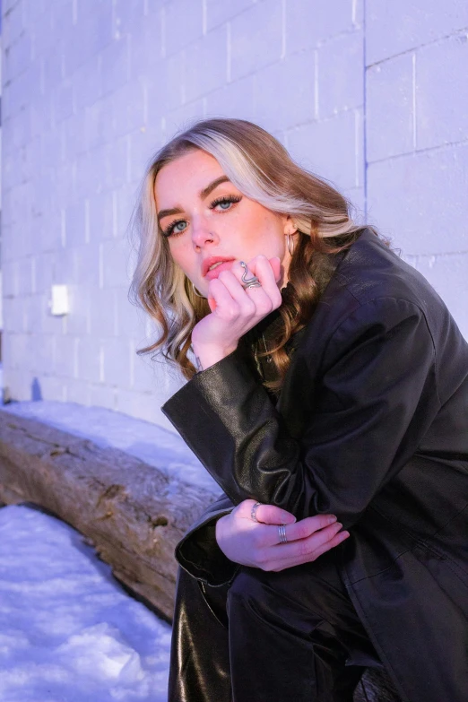 a woman sitting in the snow in front of a tree