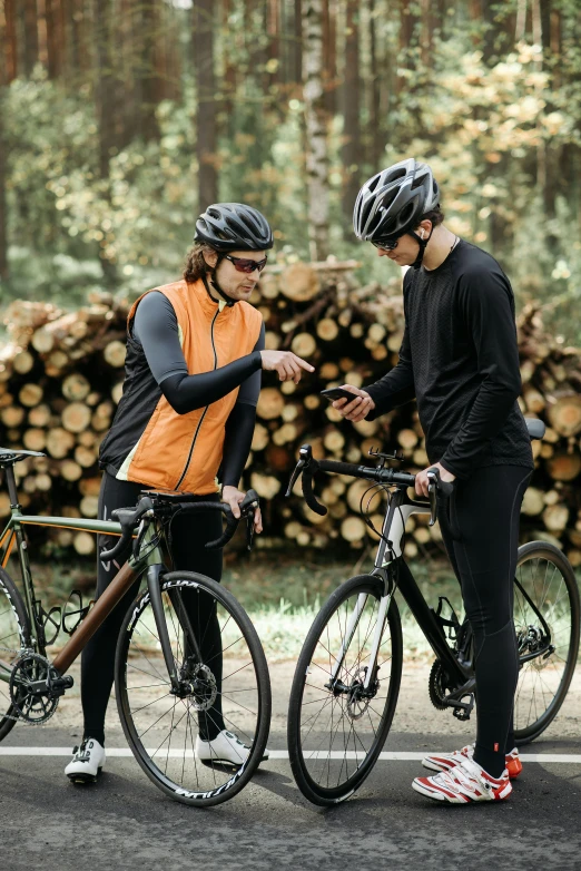 two men standing next to each other with bikes