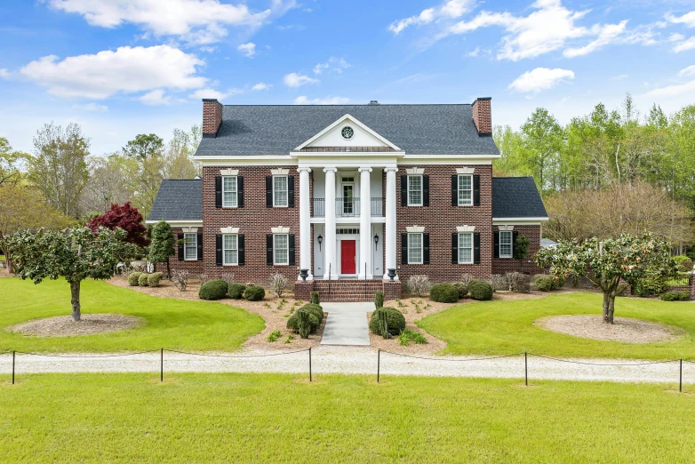 a house in the grass with trees and bushes