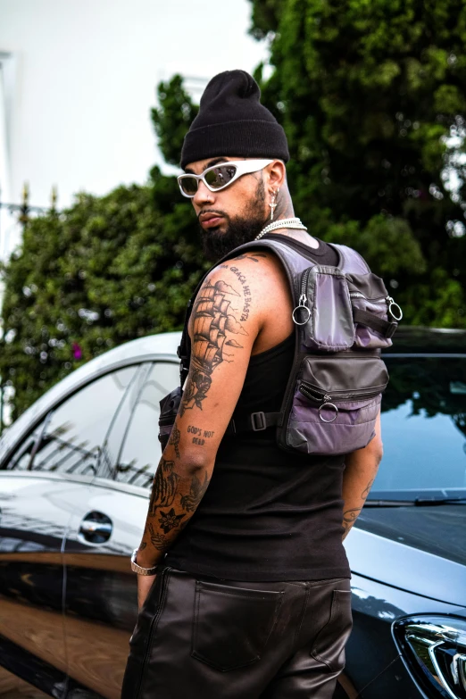 a tattooed man with sunglasses and a vest on