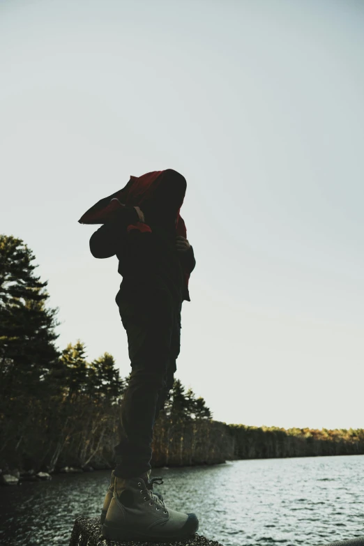 a person standing on the shore looking out into a lake