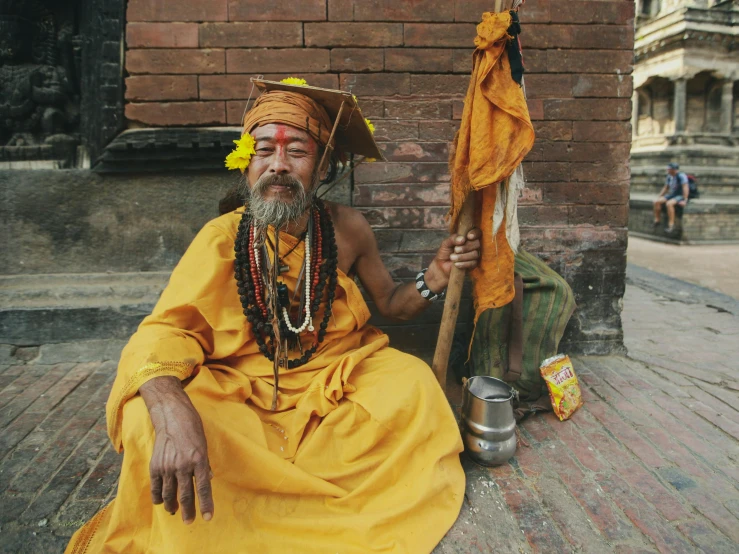 a man dressed up in yellow sits on the ground