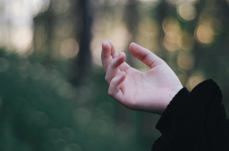 a woman with her fingers up in a forest