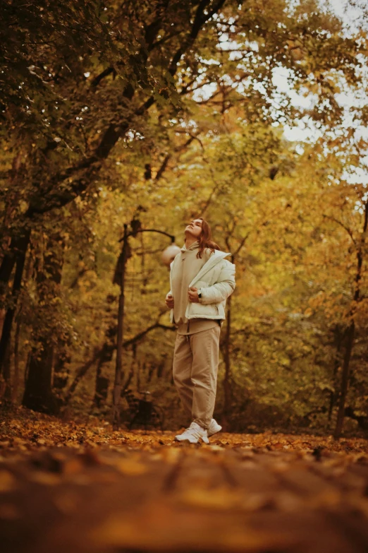 a young man standing outside in the forest