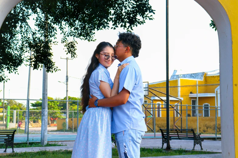 a couple standing under a tree next to each other