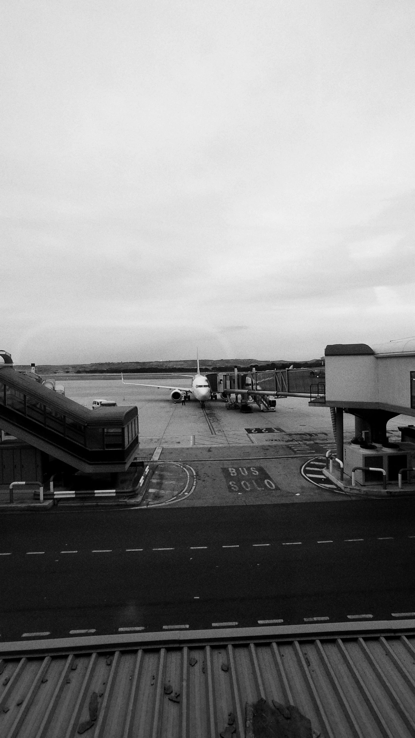 black and white image of an airport with several airplanes parked in the background