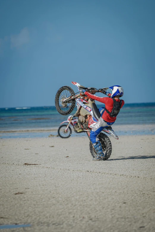 the man is riding his bike on the beach