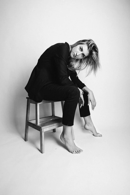 woman sitting on a small bench posing for a picture