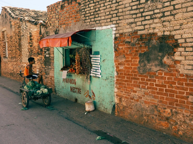 the man with the motorbike is by a building