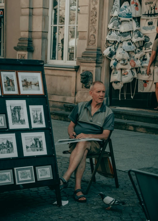 a man sitting in a chair next to a easel