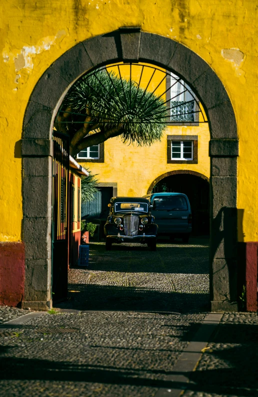 an entrance to a large, yellow building with a blue car