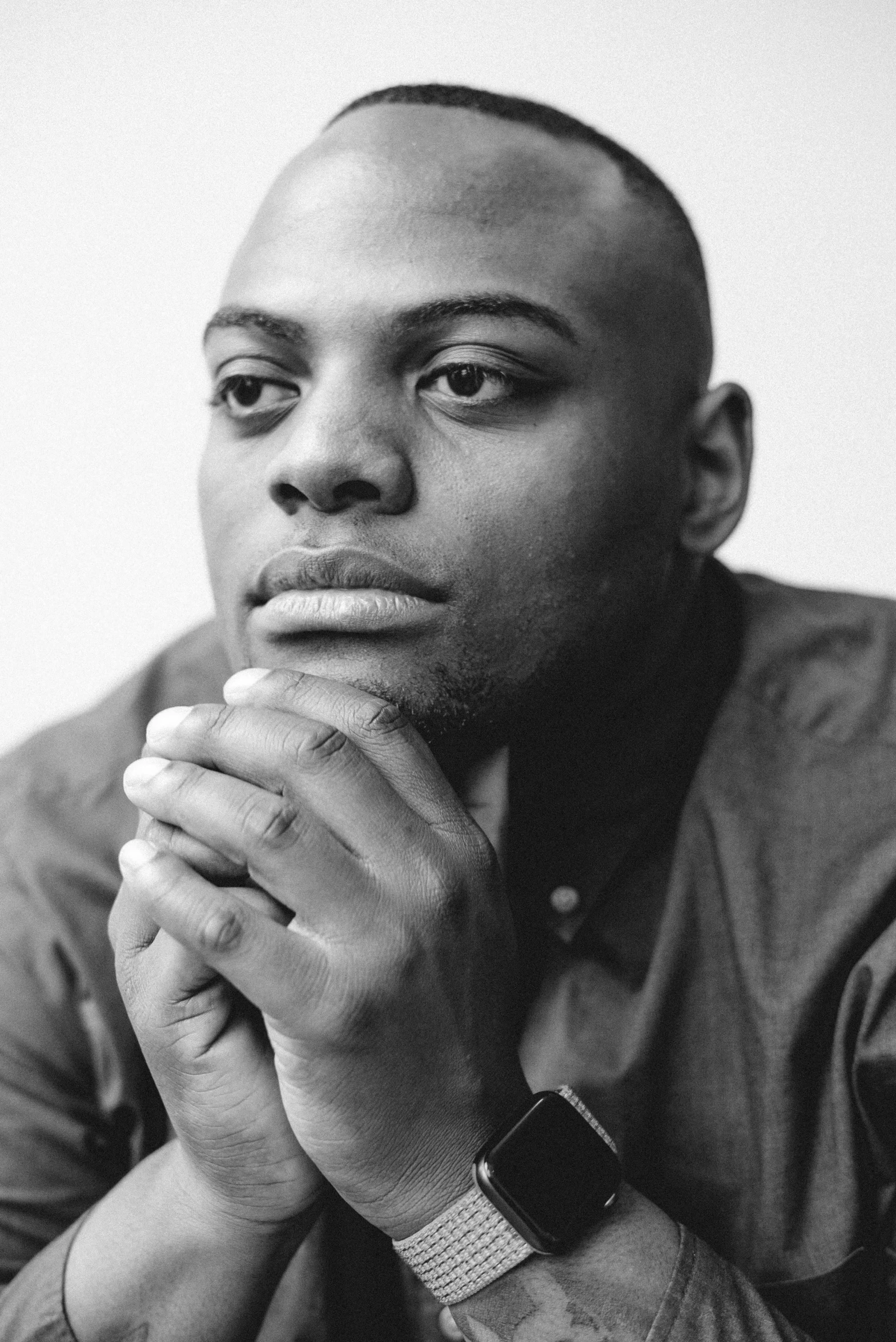 a black man sitting with his hands together