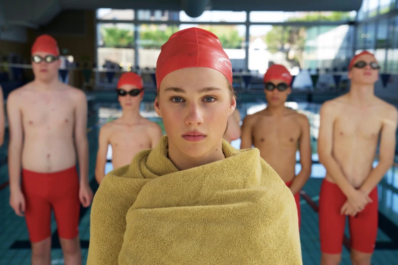 a person with an orange towel on their head and six swimmers around them