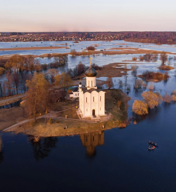 an island with a white church and a boat in a river