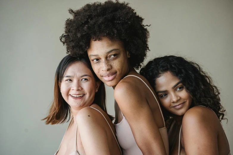 three women are in a hug on a bed