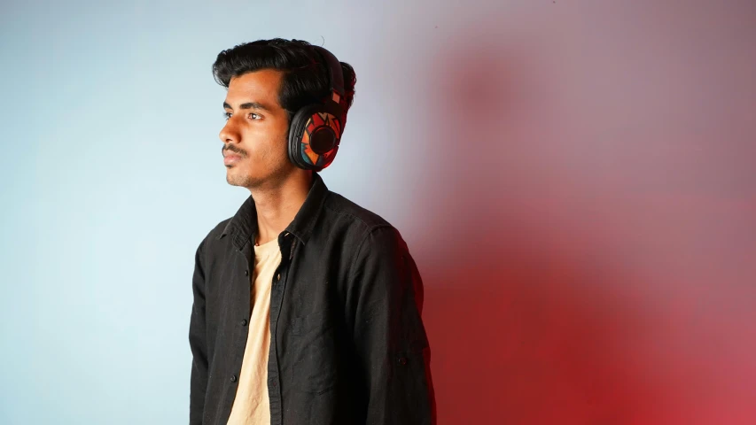 a man is standing with headphones on his ears