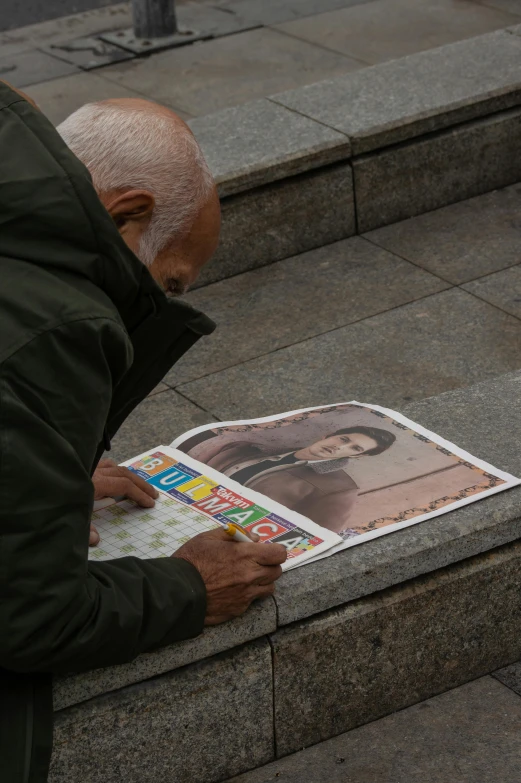 an older person looking at some newspaper in the street