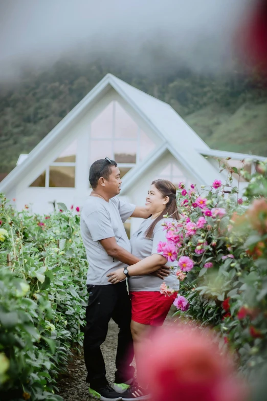 an asian couple in their greenhouse looking at each other