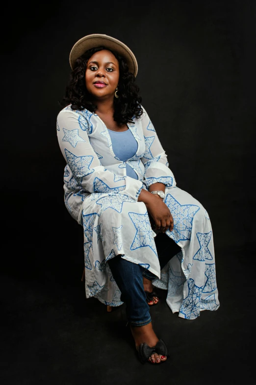 a woman with a hat and a dress sitting on a black background