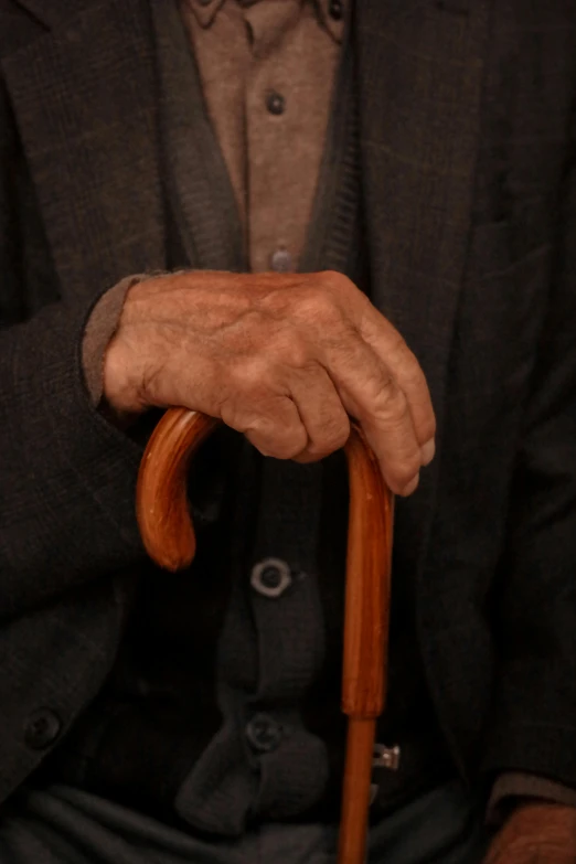 a man in a suit and tie holding an old fashioned cane