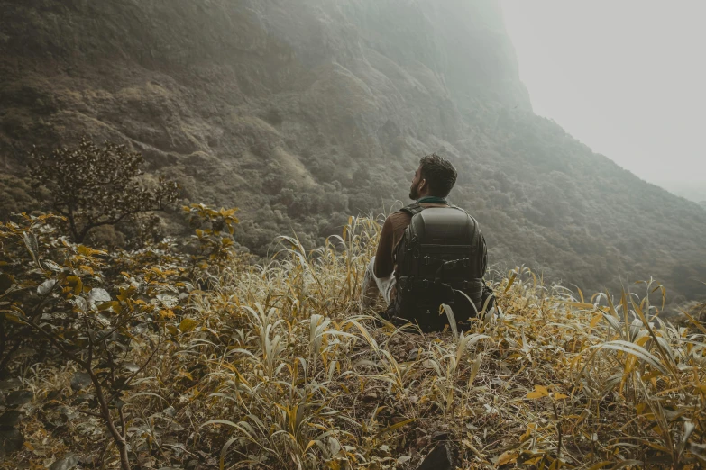 a male hiker is standing in the middle of high grass