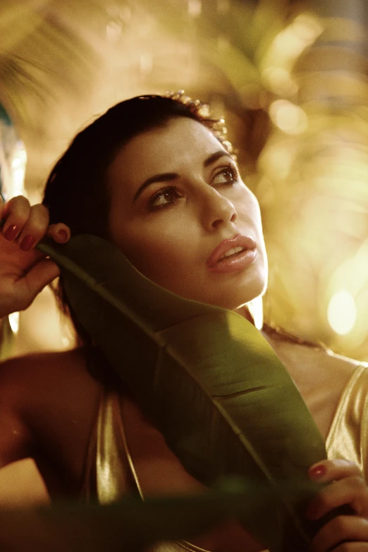 a woman posing for a po while holding a leaf