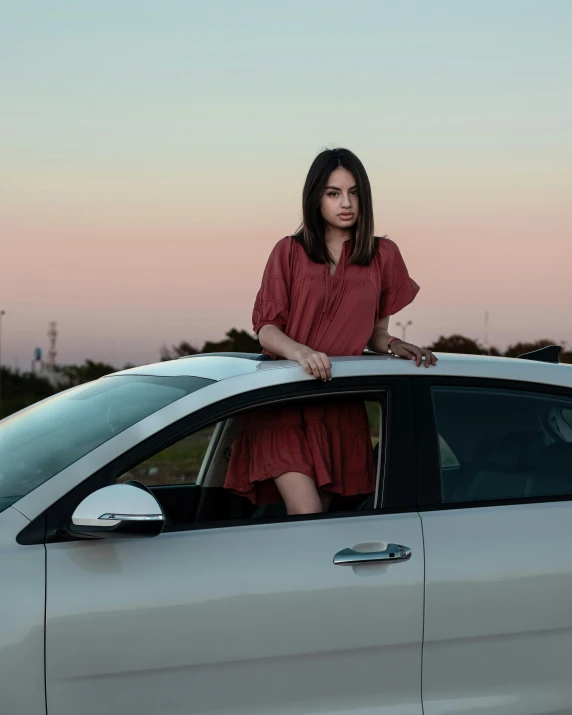 the woman is sitting on top of the car