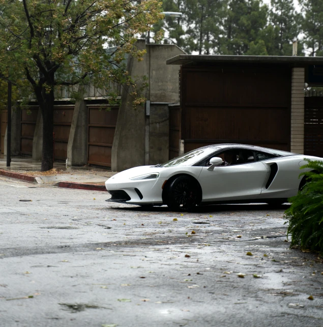 there is a white sports car parked on the street