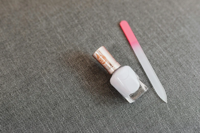 an open tube of lipstick and a knife sit on a table