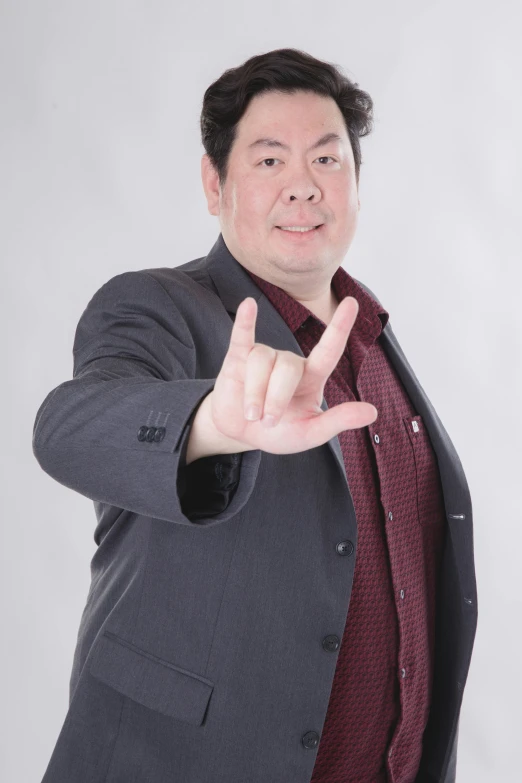 a man dressed in a suit making a hand gesture