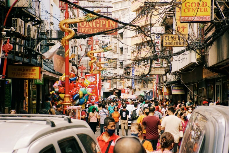 a crowded city street lined with people and large wires