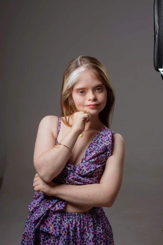 a beautiful young lady in a purple dress posing for a portrait