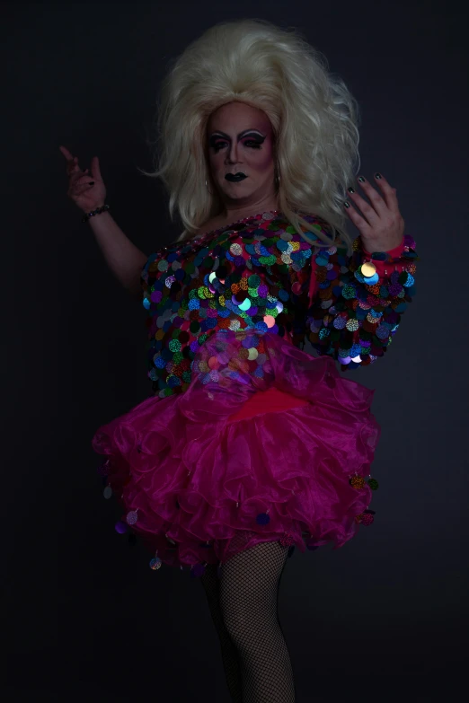 a female drag dancer with white hair, wearing a skirt and costume