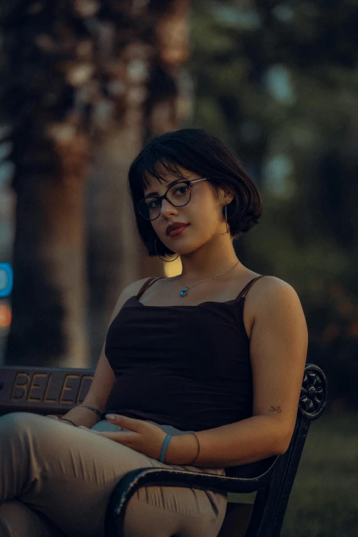 a young lady is sitting in an outdoor chair in the evening