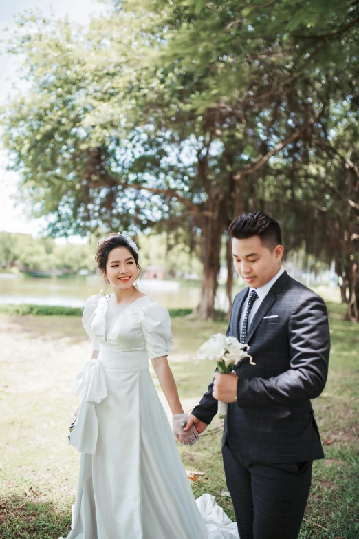 a woman in a wedding gown holding a man's hand