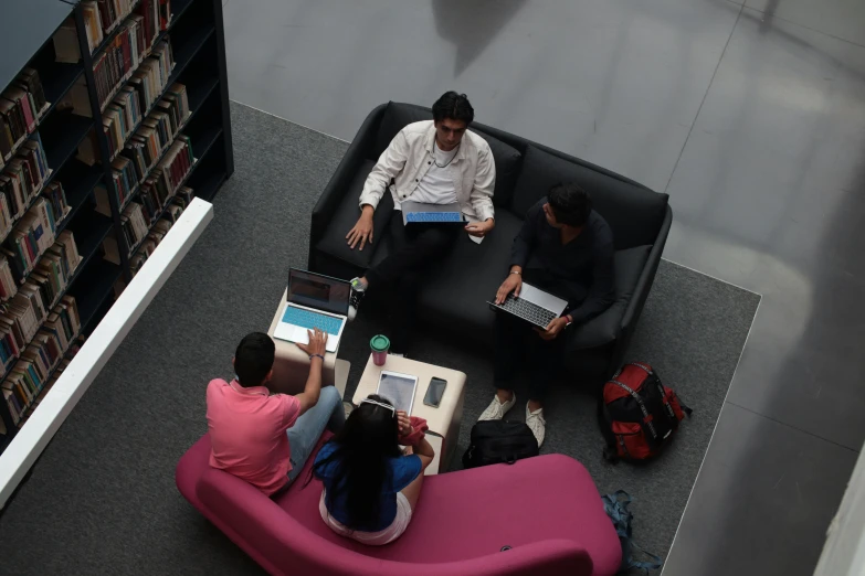 several people sitting around on two pink chairs