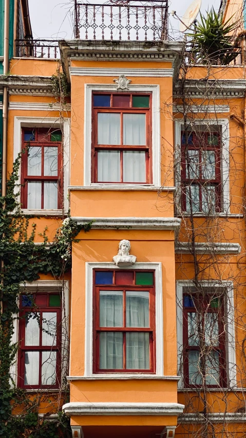 this old building is really painted orange and has an odd decoration