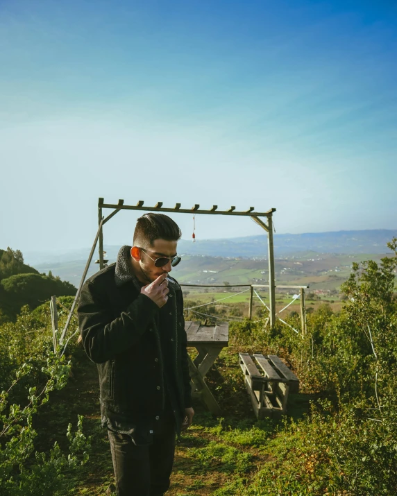 a man smoking on top of a hill