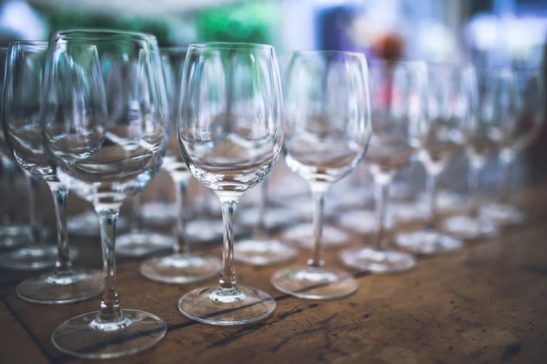 wine glasses are lined up in rows on a table