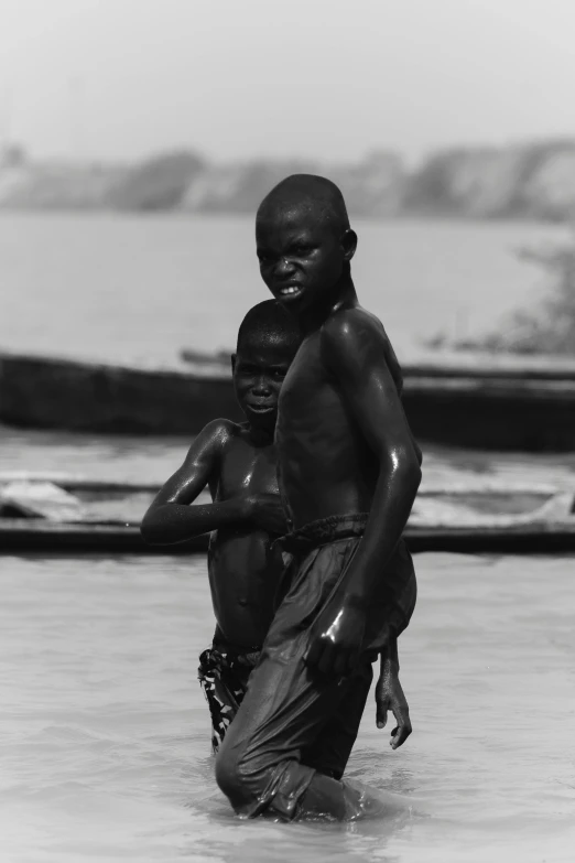 black and white pograph of young african boy playing in the water