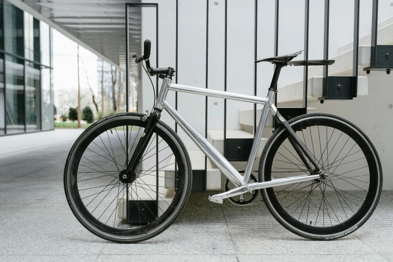 a silver bicycle is parked at the bottom of stairs