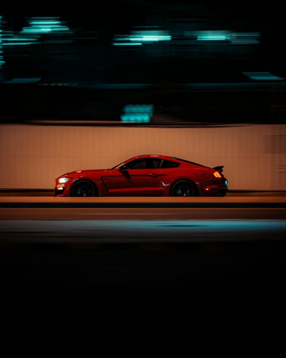 a red sports car on a freeway at night